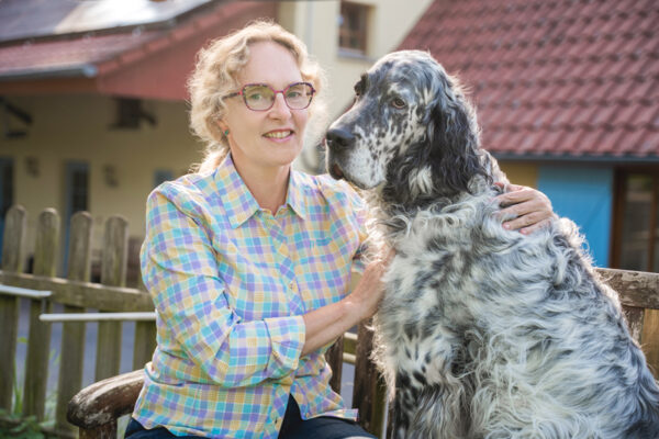 Tanja Walter mit einem Hund auf einer Bank sitzend